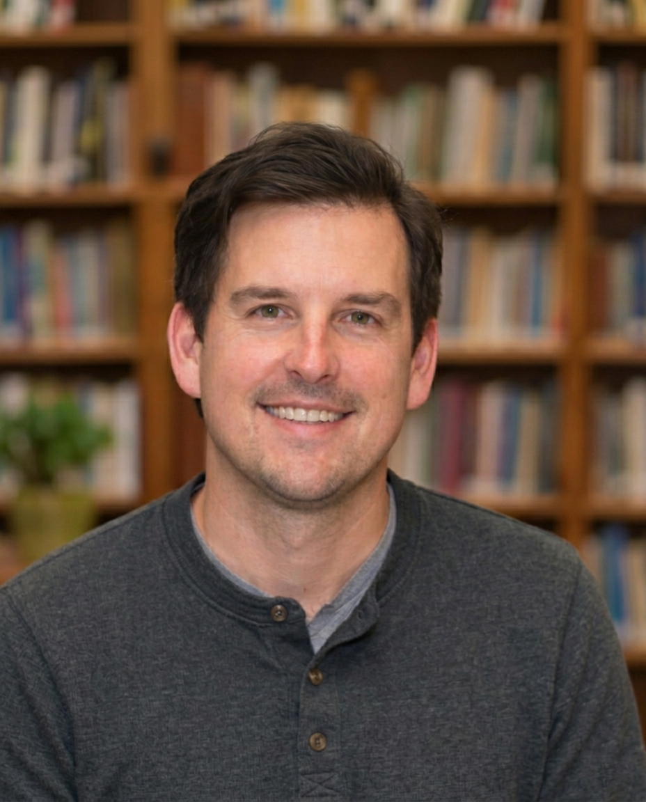 Portrait of Dan Labecki smiling in front of bookshelves